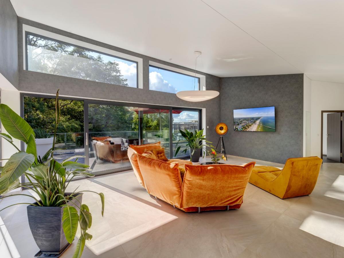 Wohnraum der Penthouse-Wohnung mit hohen Fenstern und Zugang zur Dachterrasse