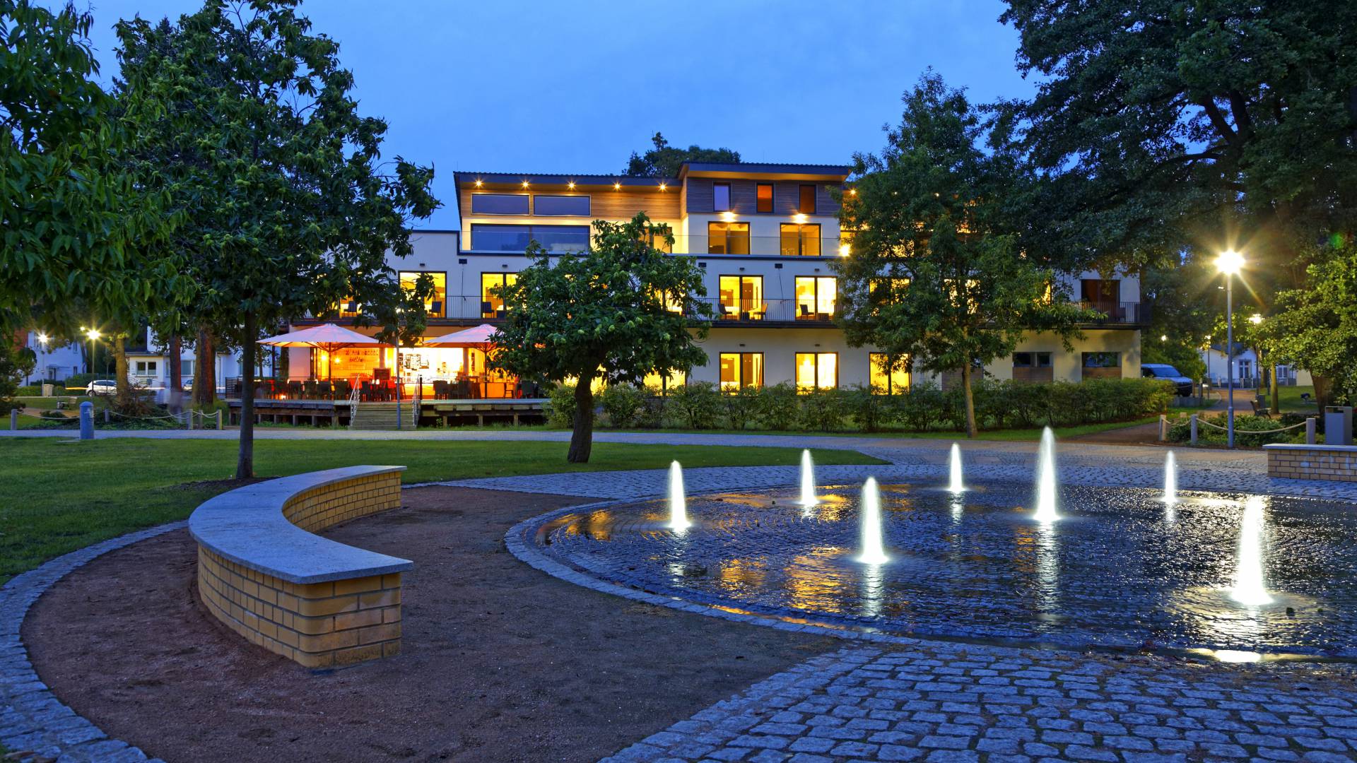 Hotel am Kurpark Zinnowitz am Abend mit Springbrunnen im Kurpark