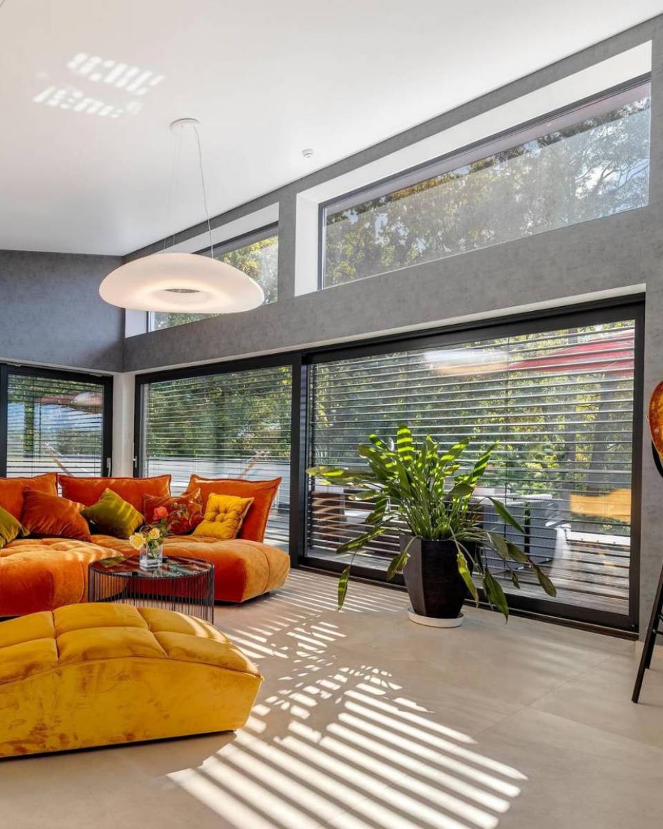 Heller Wohnraum mit bodentiefen Fenstern im Penthouse des Hotels am Kurpark